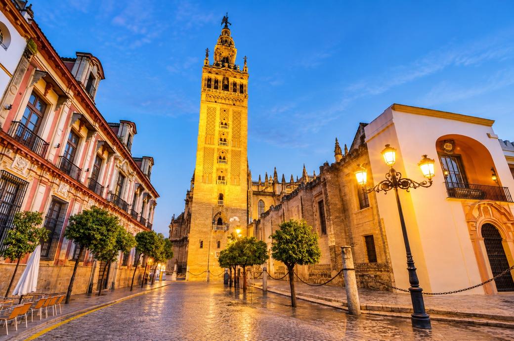 La Giralda iluminada al anochecer desde la plaza Virgen de los Reyes