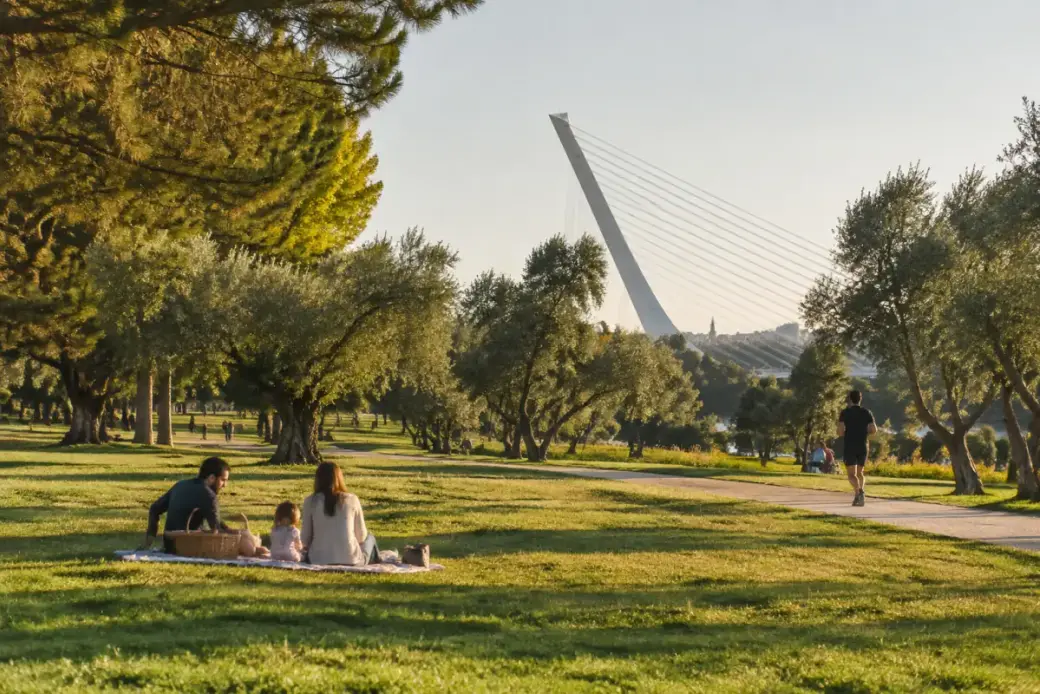 Praderas del parque del Alamillo con familias y el puente del Alamillo al fondo