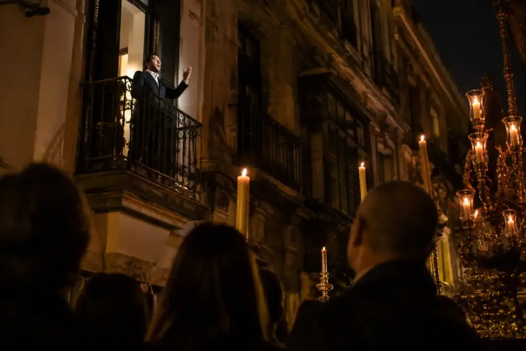 Una saeta cantada desde un balcón al paso de una procesión