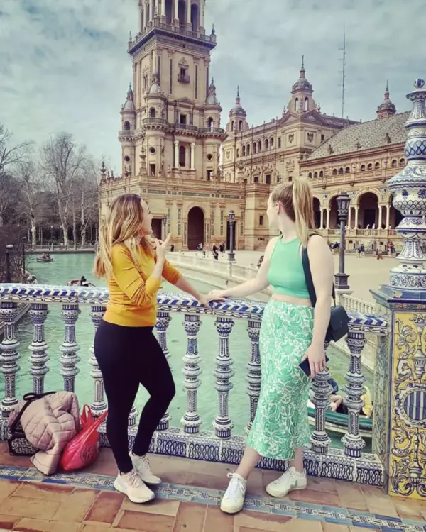 María explicando la Plaza de España a una viajera junto a la balaustrada de cerámica
