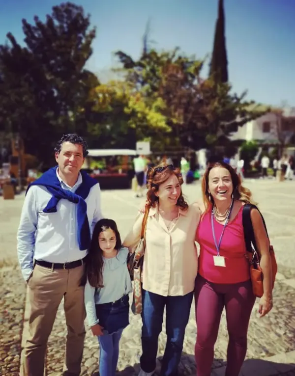 María sonriendo junto a una familia con su hija durante una visita por Sevilla