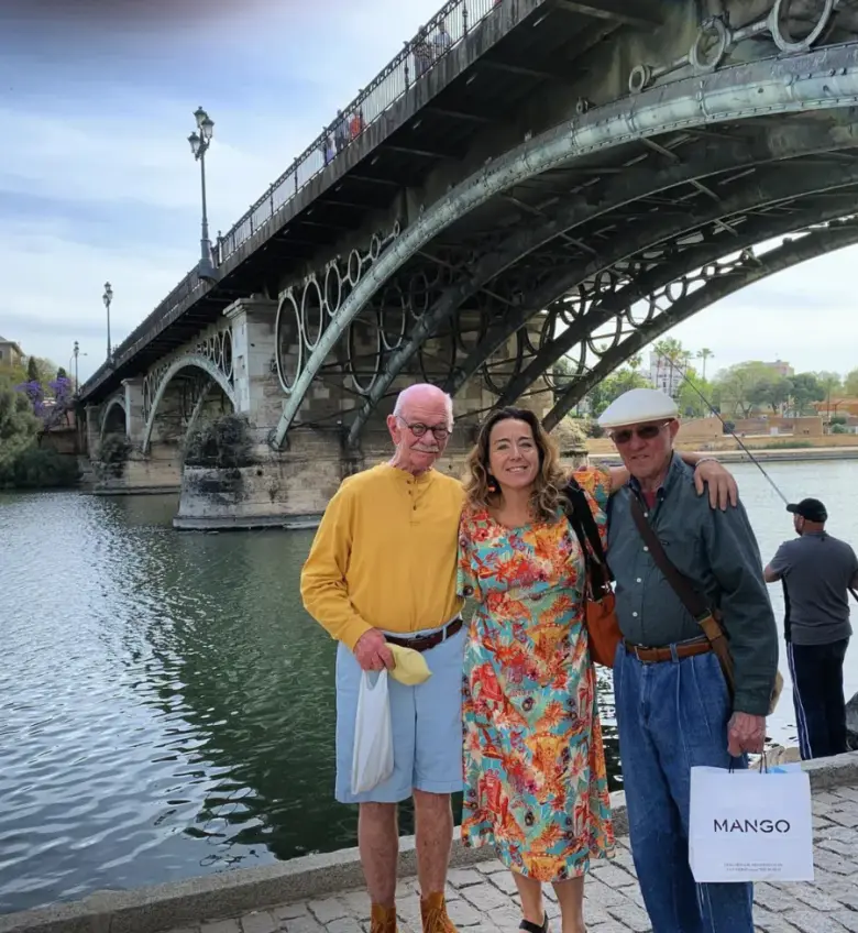 María with two travellers on the bank of the Guadalquivir beneath Triana Bridge